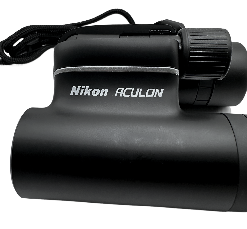 Crni Nikon Aculon T01 dalekozor s remenom prikazan izbliza, idealan za promatranje na otvorenom.