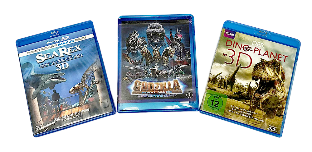 Kolme dinosaurusaiheista Blu-ray-levyä kotiteatteriin mustalla taustalla.