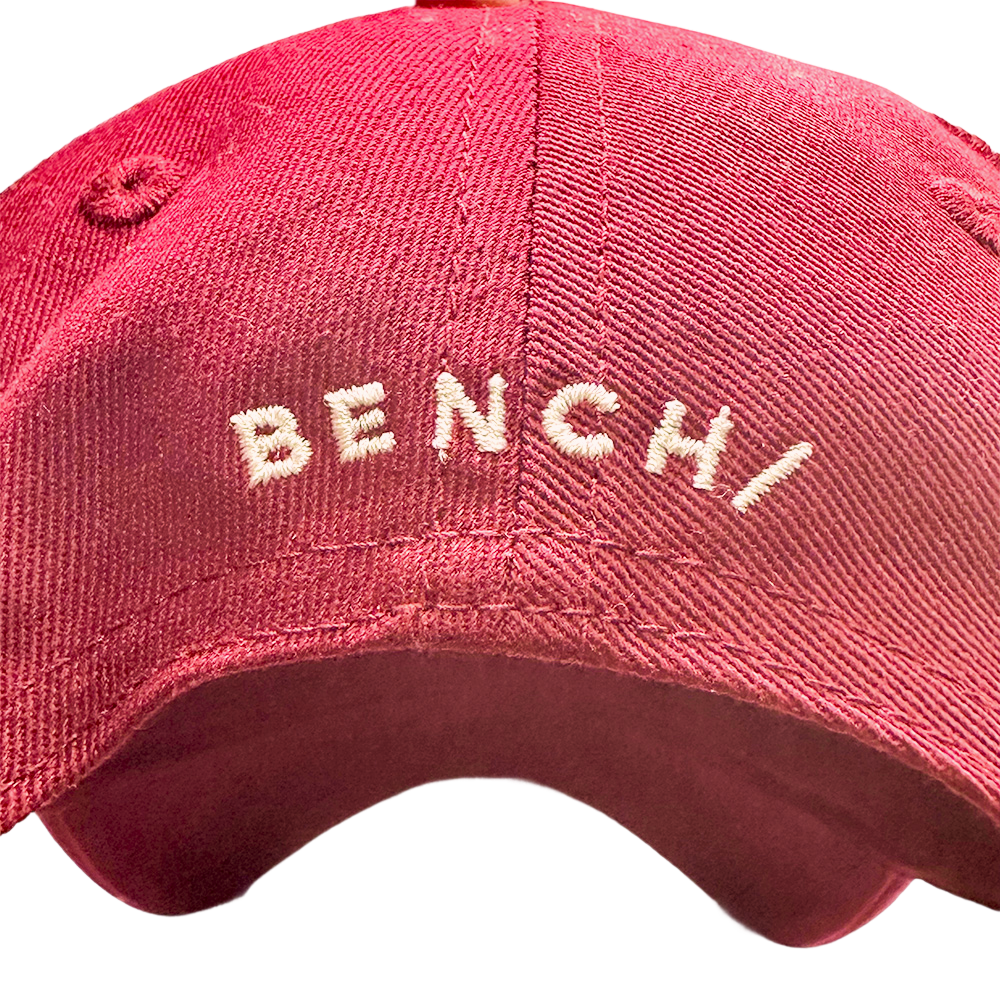 Punainen Bench Baseball-lippis, jossa valkoinen logo edessä. Tyylikäs päähine arkeen ja urheiluun.