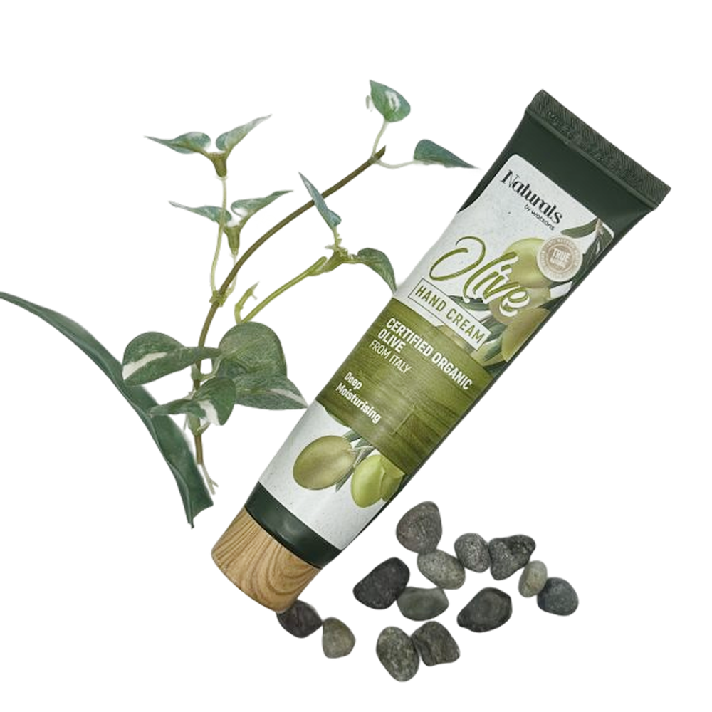 Paras käsivoide: Naturals Oliivi Käsivoide, tuubissa oliivin oksa ja pieniä kiviä taustalla