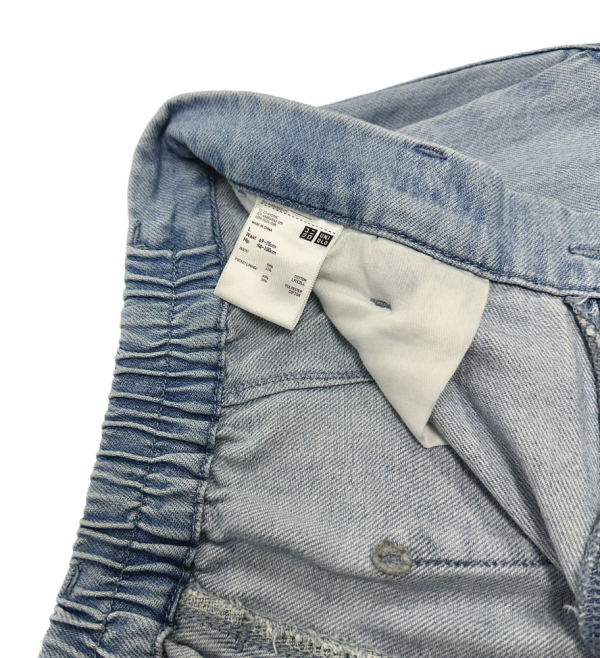 Detalj iznutra Uniqlo ženskih širokih hlača, prikazuje elastičan pojas i etiketu s podacima.