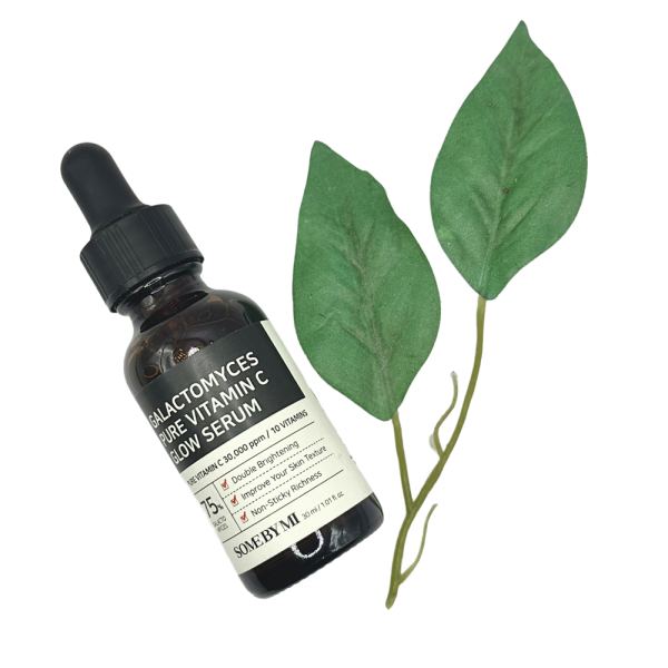 Some By Mi Vitamin C Serum bottle for dark marks skin, shown with green leaves for a natural look.