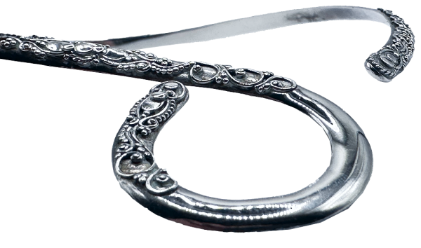 Close-up of a silver open collar necklace with intricate looped and engraved detailing on both ends.