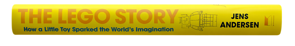 The LEGO Story -tietokirjan selkämys, keltainen kansi ja Jens Andersenin nimi näkyvissä.