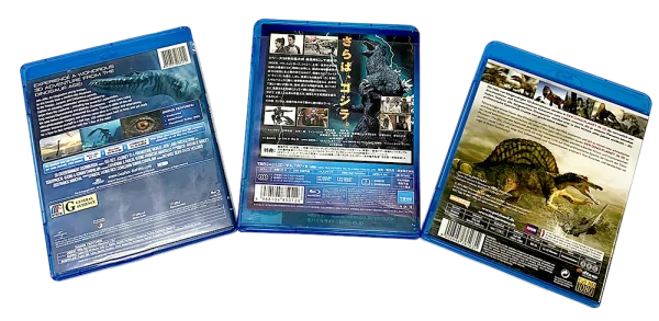 Three Dinosaur Blu-ray cases showing detailed back covers with images of prehistoric creatures and movie information.