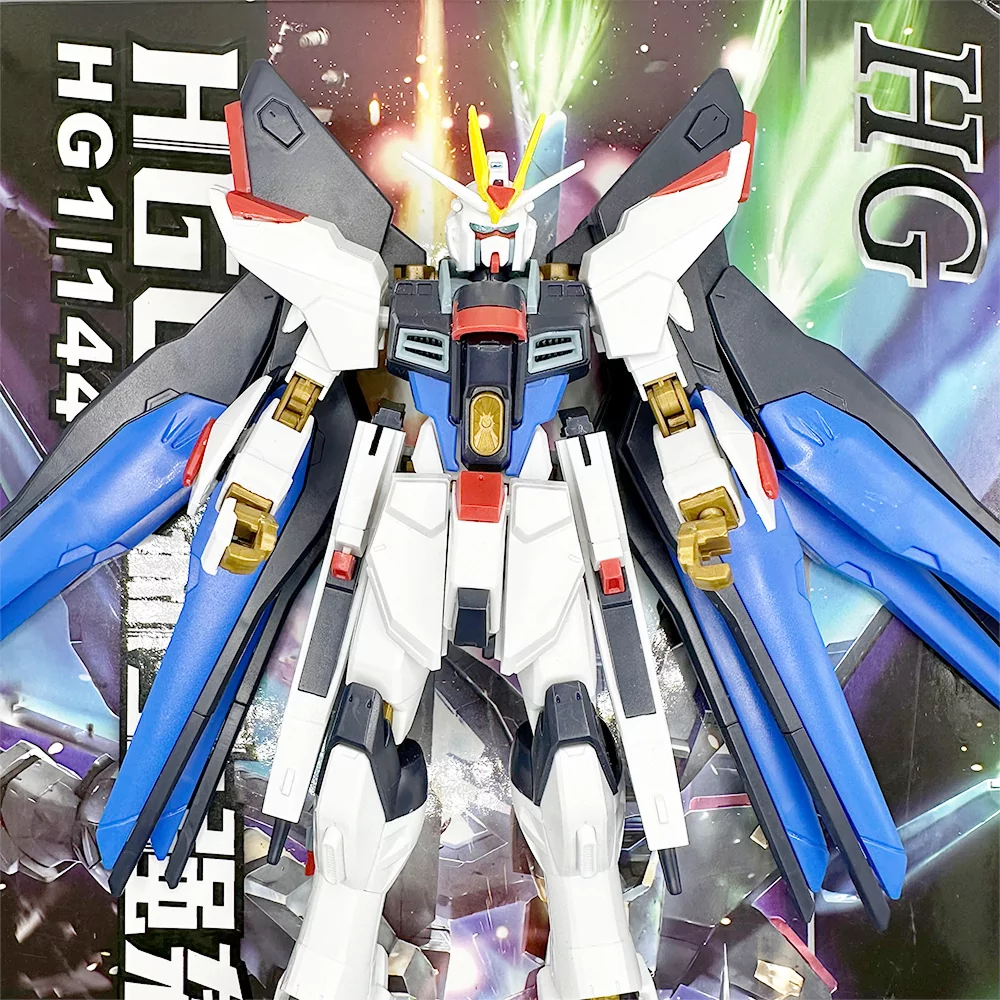 Gundam Strike Freedom figura s plavim i zlatnim detaljima, prikazana ispred originalnog pakiranja.