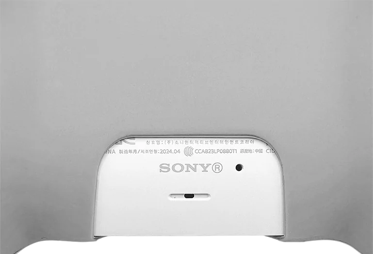 Zbliżenie na tył kontrolera PlayStation 5, widoczne logo Sony oraz port ładowania.