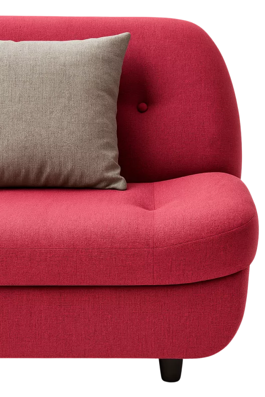 Close-up of a red modern sofa with curved edges and a light gray accent pillow on the seat.