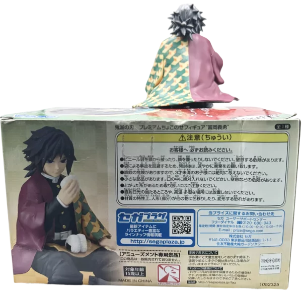 Kifigurini cha Tomioka kutoka SEGA Demon Slayer, kimekaa juu ya boksi la bidhaa.