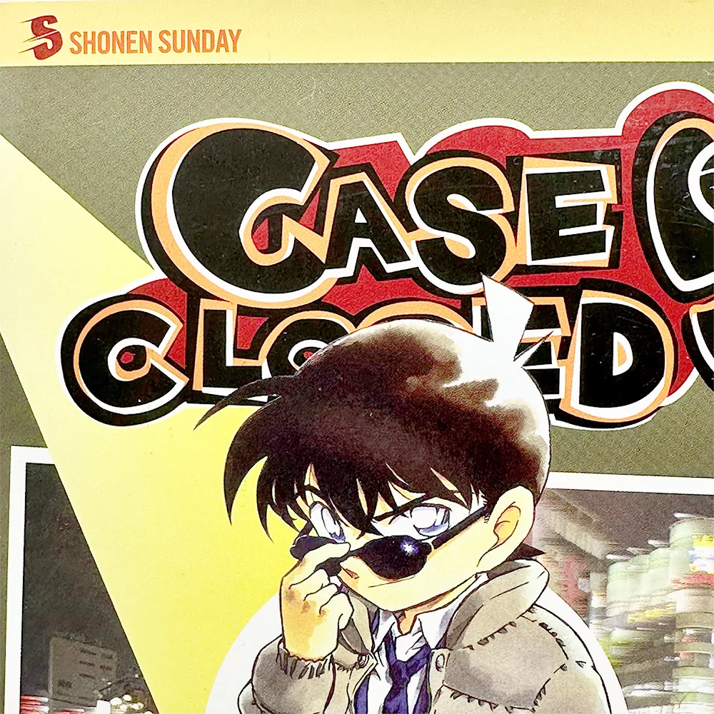 Omslaget till Detective Conan Volym 37 visar huvudkaraktären med solglasögon och en allvarlig min.