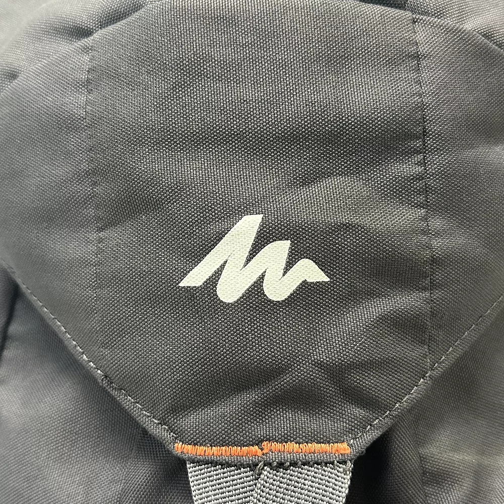 Close-up of Quechua Arpenaz Backpack in gray, featuring the white Quechua logo on the fabric.