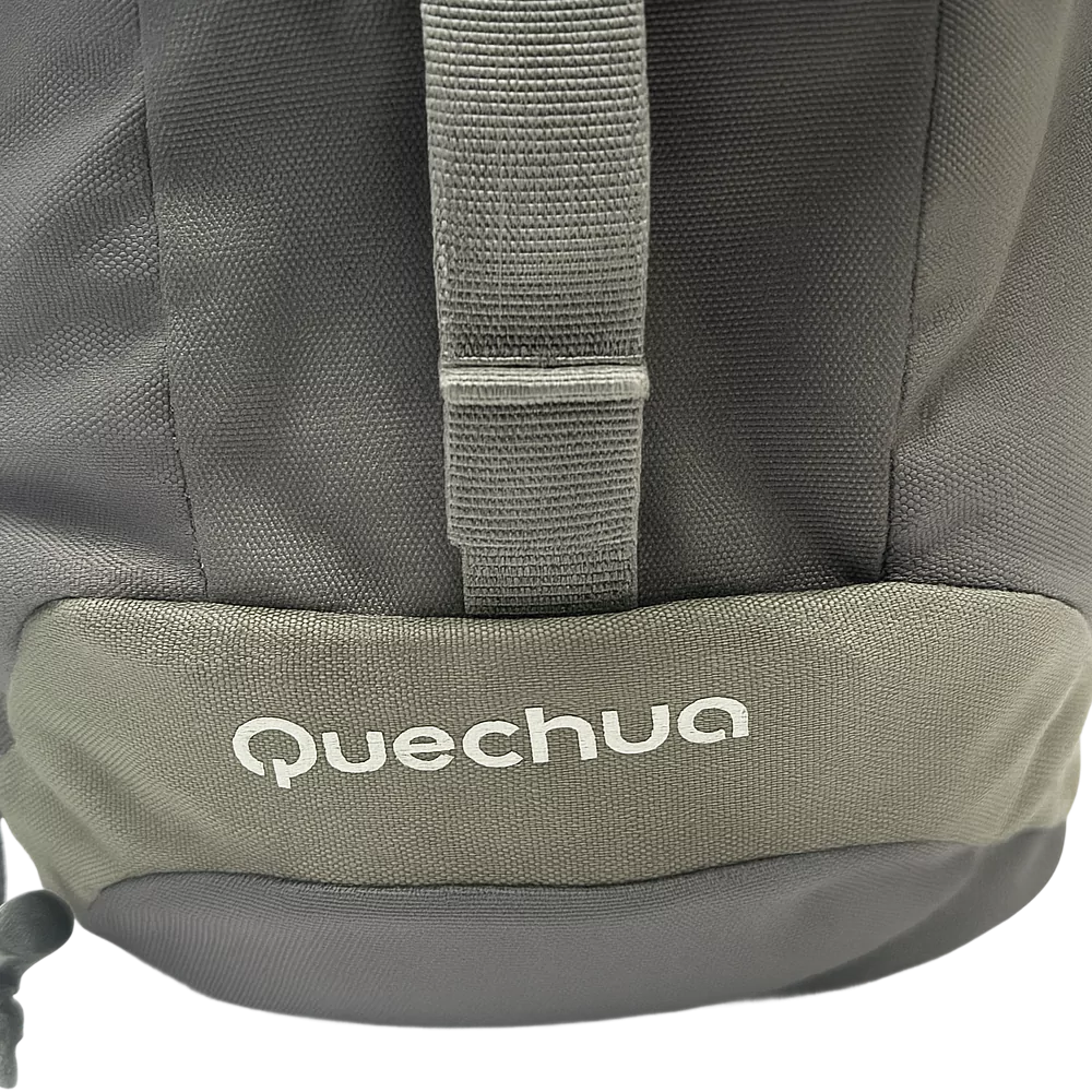 Close-up of the bottom corner of a Quechua Arpenaz Backpack showing the brand logo on grey fabric.