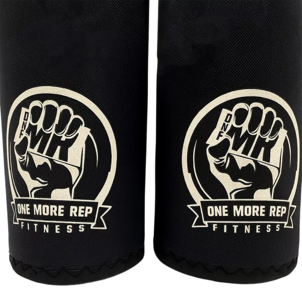 Close-up of One More Rep Fitness Kneepads featuring a fist logo and brand name on black fabric.