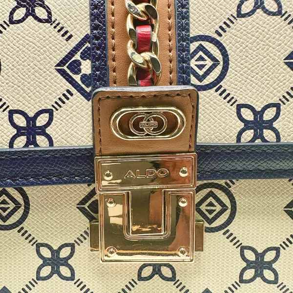 Detailný záber na zámok kabelky Aldo Donelly so vzorom a kovovým logom.
