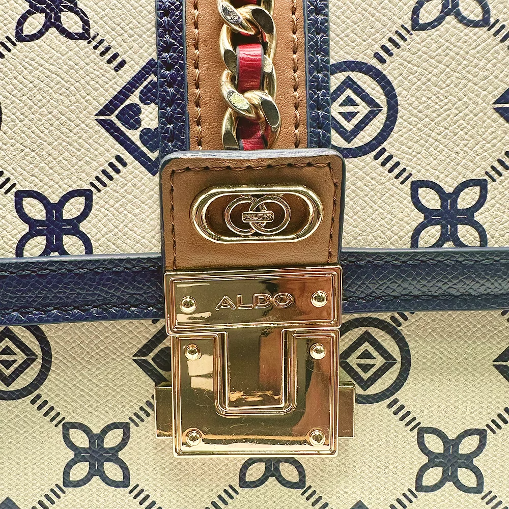Detailný záber na zámok kabelky Aldo Donelly so vzorom a kovovým logom.