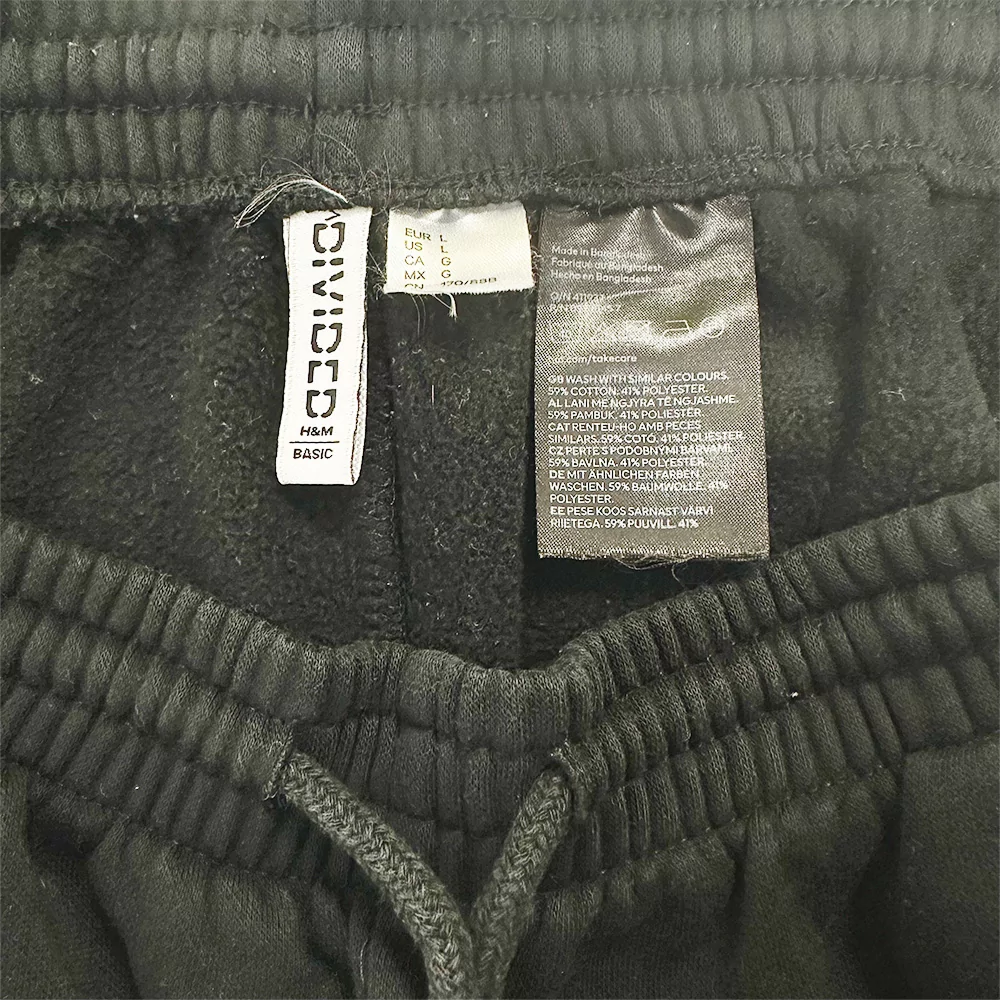 Fekete H&M női basic melegítőnadrág derékrész, címkékkel és gumírozott megoldással.