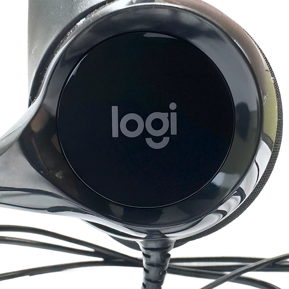 Lähikuva Logitech H390 langallisen kuulokemikrofonin korvakupista, jossa näkyy "logi" logo.