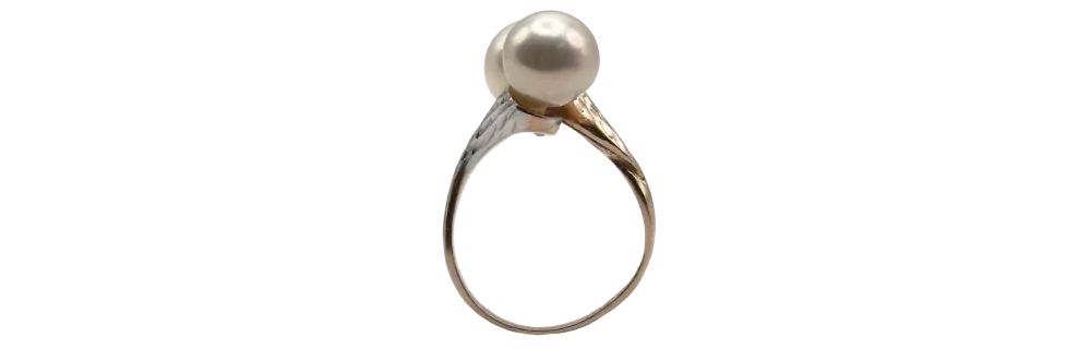 Zlati prstan z okroglo biserno perlo, prikazan od strani na belem ozadju.