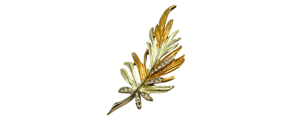 Two-tone gold leaf brooch with silver and gold detailing, accented by sparkling crystals.
