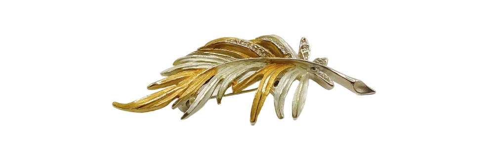 Two-tone gold leaf brooch featuring intricate, overlapping gold and silver-toned metalwork in a leaf design.