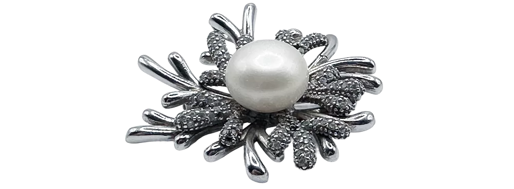 Srebrna broša s koraljnim detaljem u obliku cvijeta, savršena za elegantan izgled.