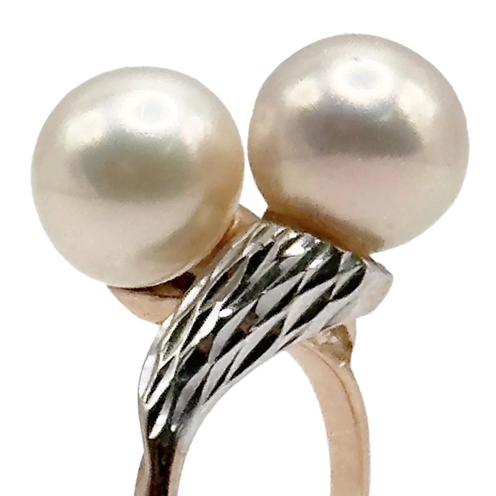 Zlati prstan z dvema biseroma in srebrnim okrasjem, prikazan za prodajo.