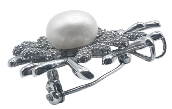 Srebrna broša s koraljnim detaljem i biserom, elegantan ukras za odjeću.