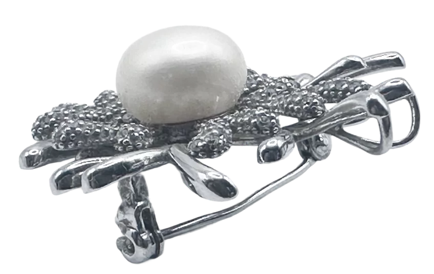 Srebrna broša s koraljnim detaljem i biserom, elegantan ukras za odjeću.