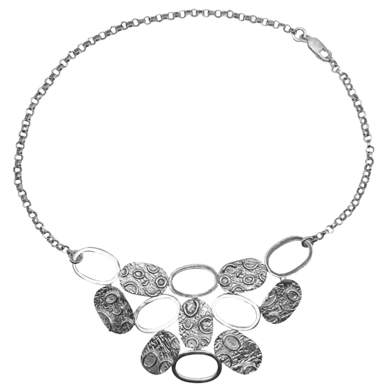 Srebrny naszyjnik z ozdobnymi dyskami i owalnymi elementami, widok produktu na stronie sklepu.