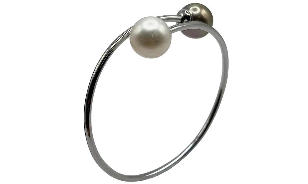 Bracciale elegante con perla bianca e nera su estremità, design minimalista in metallo lucido.