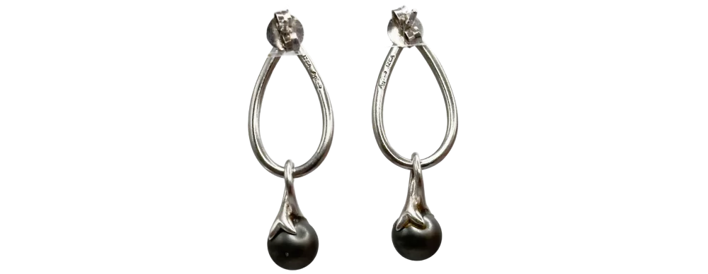 Silberne Tropfenohrringe mit schwarzen Perlen, elegantes Design auf weißem Hintergrund.