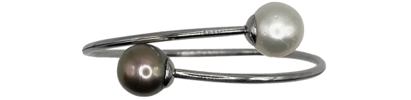 Bracciale in argento con una perla bianca e una perla nera, design elegante e moderno.