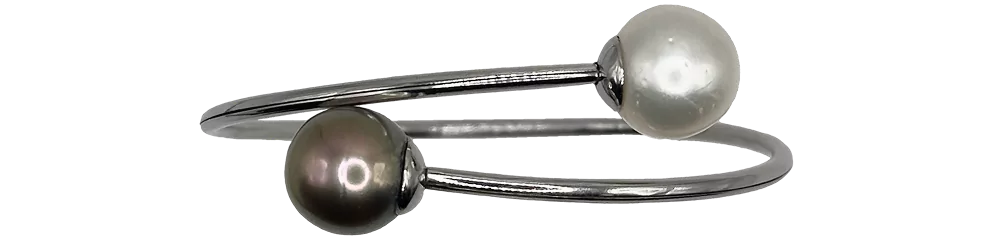 Bracciale in argento con una perla bianca e una perla nera, design elegante e moderno.