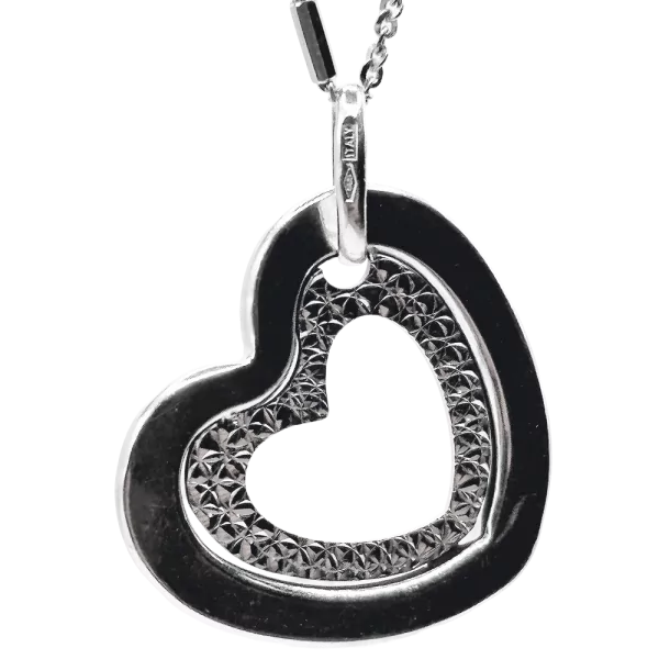 Silver heart pendant necklace with textured inner detailing, hanging from a delicate chain.