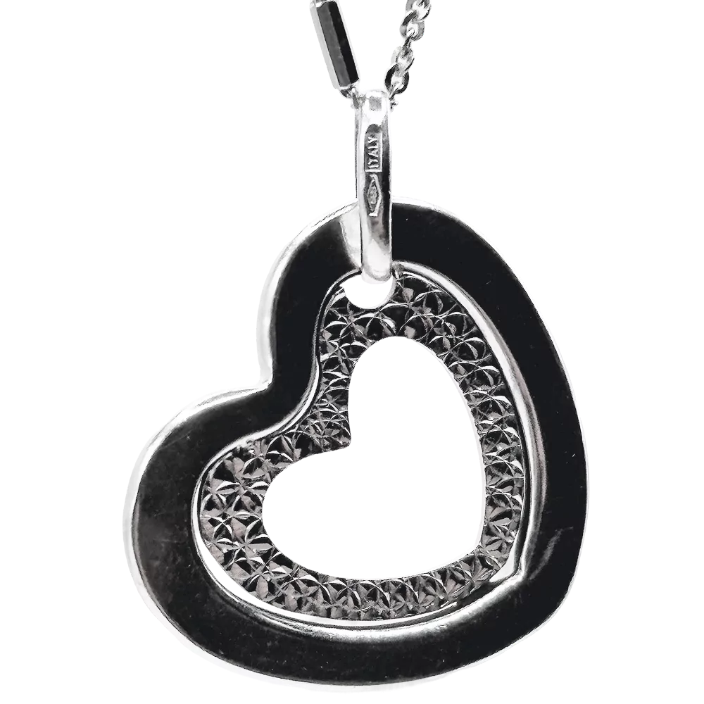 Silver heart pendant necklace with textured inner detailing, hanging from a delicate chain.